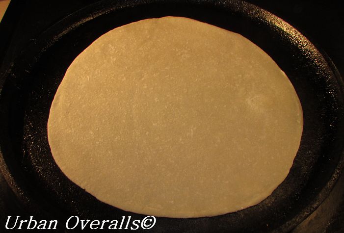 uncooked flour tortilla on the skillet